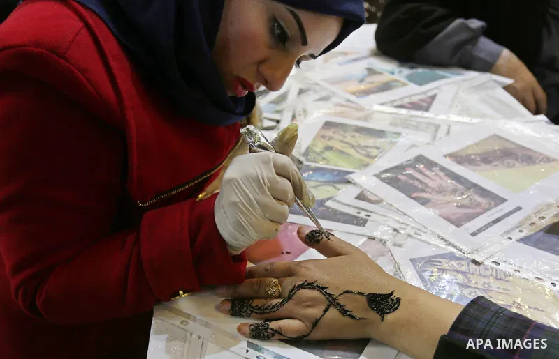Palestinian women take part during Palestinian Heritage Exhibition on the theme ''Products of our women'', in Gaza City, on March 19, 2017. Photo by Ashraf Amra