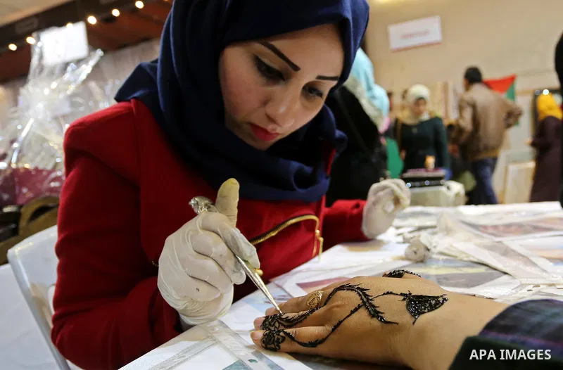 Palestinian women take part during Palestinian Heritage Exhibition on the theme ''Products of our women'', in Gaza City, on March 19, 2017. Photo by Ashraf Amra