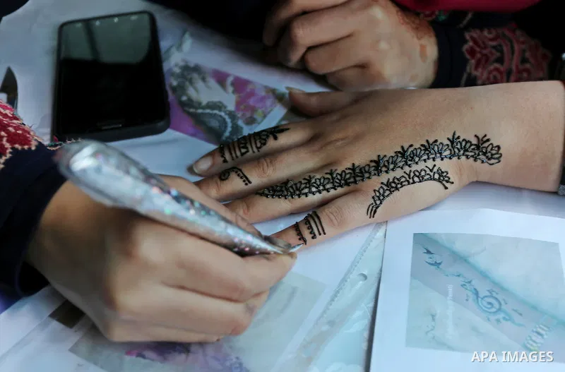 Palestinian women take part during Palestinian Heritage Exhibition on the theme ''Products of our women'', in Gaza City, on March 19, 2017. Photo by Ashraf Amra
