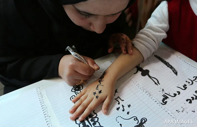 Palestinian women take part during Palestinian Heritage Exhibition on the theme ''Products of our women'', in Gaza City, on March 19, 2017. Photo by Ashraf Amra