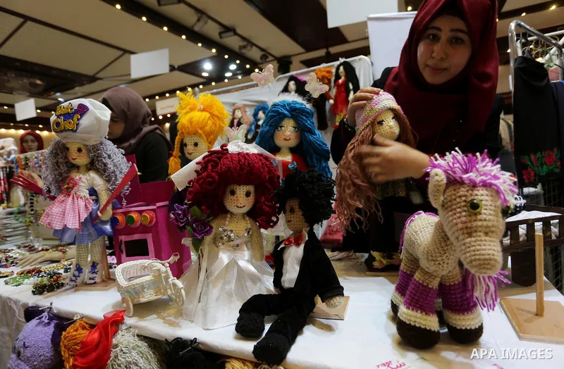 Palestinian women take part during Palestinian Heritage Exhibition on the theme ''Products of our women'', in Gaza City, on March 19, 2017. Photo by Ashraf Amra