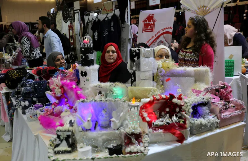 Palestinian women take part during Palestinian Heritage Exhibition on the theme ''Products of our women'', in Gaza City, on March 19, 2017. Photo by Ashraf Amra