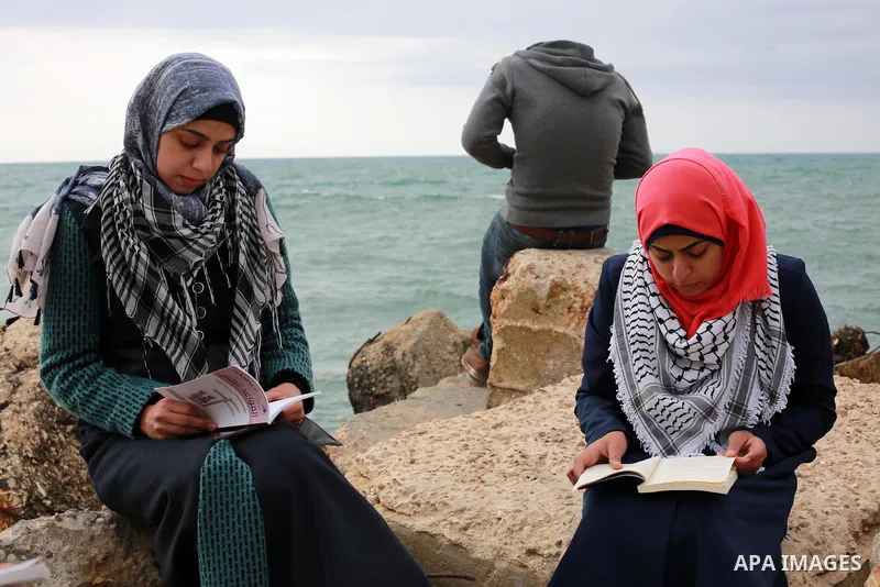 Palestinians participate in a reading human chain at the Gaza seaport on March 19, 2017. Photo by Mohammed Asad