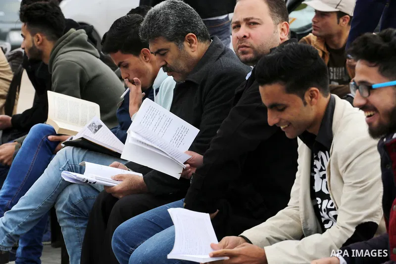 Palestinians participate in a reading human chain at the Gaza seaport on March 19, 2017. Photo by Mohammed Asad