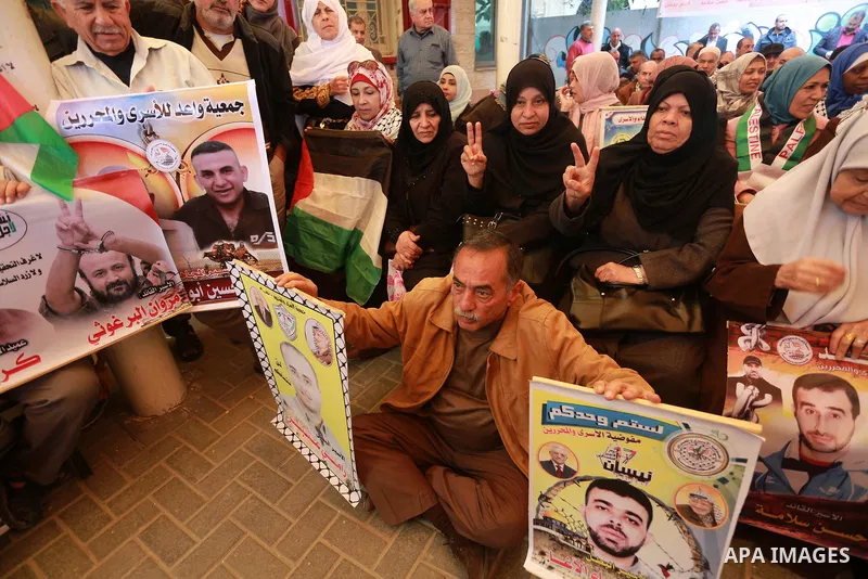 Palestinians hold placards during a protest to show solidarity with Palestinian prisoners held in Israeli Jails, in front of Red cross office in Gaza city, on March 20, 2017. Photo by Mohammed Asad