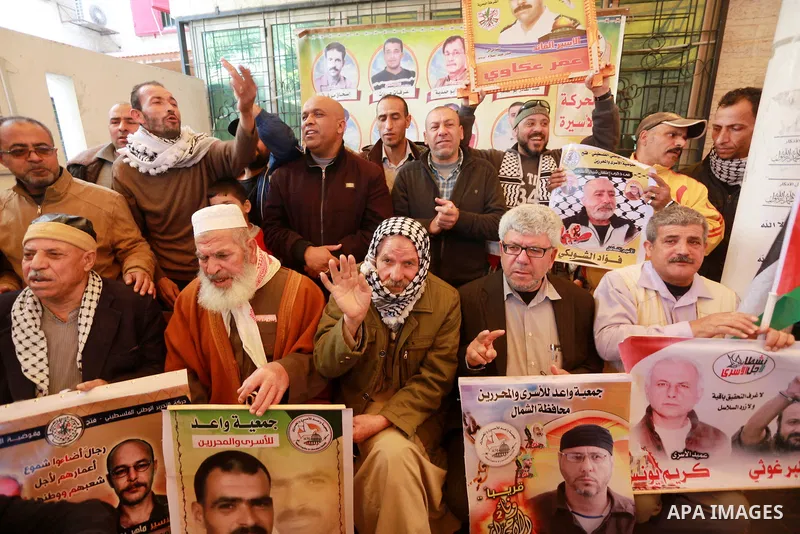 Palestinians hold placards during a protest to show solidarity with Palestinian prisoners held in Israeli Jails, in front of Red cross office in Gaza city, on March 20, 2017. Photo by Mohammed Asad