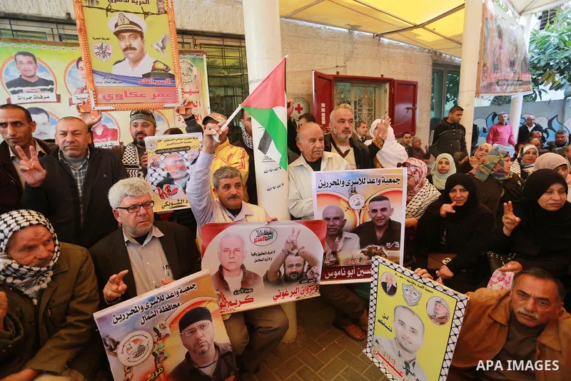 Palestinians hold placards during a protest to show solidarity with Palestinian prisoners held in Israeli Jails, in front of Red cross office in Gaza city, on March 20, 2017. Photo by Mohammed Asad
