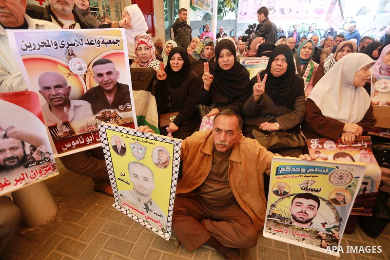 Palestinians hold placards during a protest to show solidarity with Palestinian prisoners held in Israeli Jails, in front of Red cross office in Gaza city, on March 20, 2017. Photo by Mohammed Asad