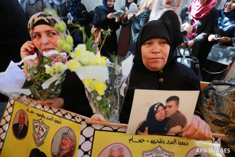 Palestinians hold placards during a protest to show solidarity with Palestinian prisoners held in Israeli Jails, in front of Red cross office in Gaza city, on March 20, 2017. Photo by Mohammed Asad