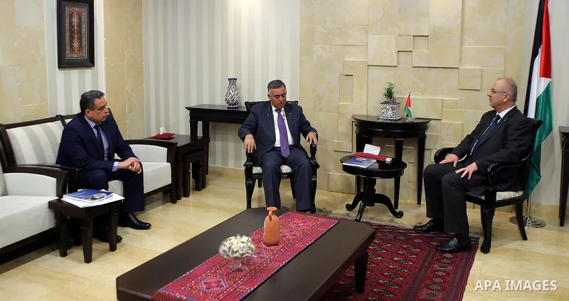 Palestinian Prime Minister Rami Hamdallah receives the report of the achievements of the Municipal Lending Fund for the year 2016, in the West Bank city of Ramallah on March 20, 2017. Photo by Prime Minister Office
