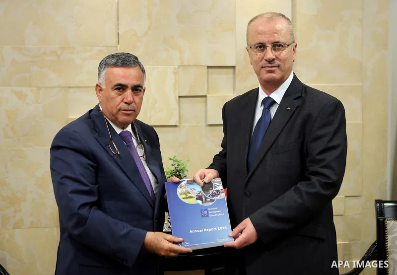Palestinian Prime Minister Rami Hamdallah receives the report of the achievements of the Municipal Lending Fund for the year 2016, in the West Bank city of Ramallah on March 20, 2017. Photo by Prime Minister Office