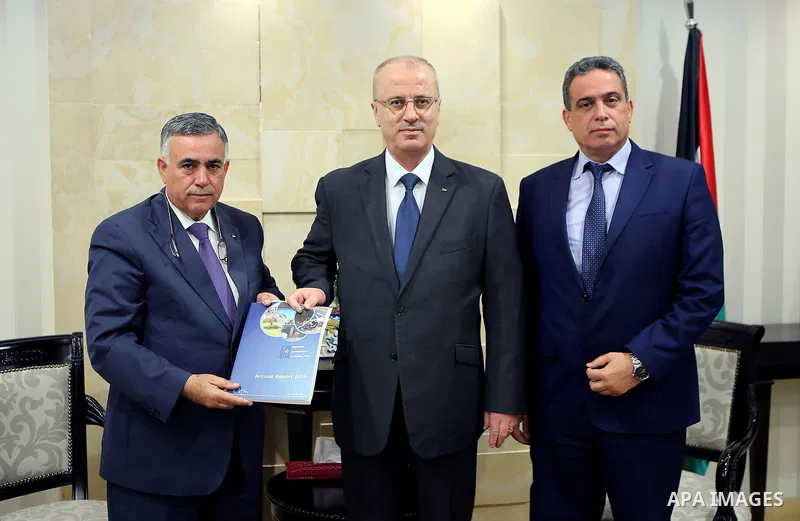 Palestinian Prime Minister Rami Hamdallah receives the report of the achievements of the Municipal Lending Fund for the year 2016, in the West Bank city of Ramallah on March 20, 2017. Photo by Prime Minister Office