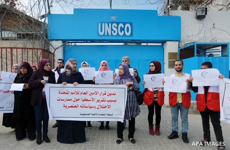 Palestinians hold banners during a protest against the U.N. Secretary-General Antonio Guterres decision to remove Israeli 'apartheid' report from Economic and Social Commission for Western Asia (ESCWA) website, in front...
