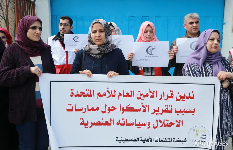 Palestinians hold banners during a protest against the U.N. Secretary-General Antonio Guterres decision to remove Israeli 'apartheid' report from Economic and Social Commission for Western Asia (ESCWA) website, in front...