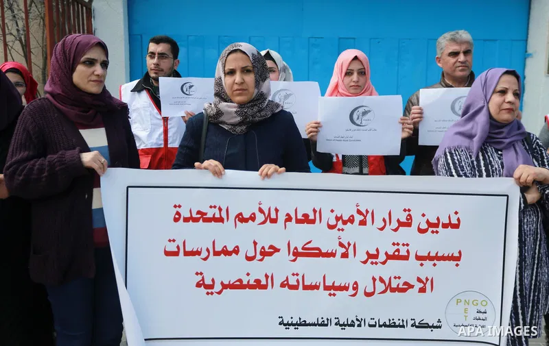Palestinians hold banners during a protest against the U.N. Secretary-General Antonio Guterres decision to remove Israeli 'apartheid' report from Economic and Social Commission for Western Asia (ESCWA) website, in front...