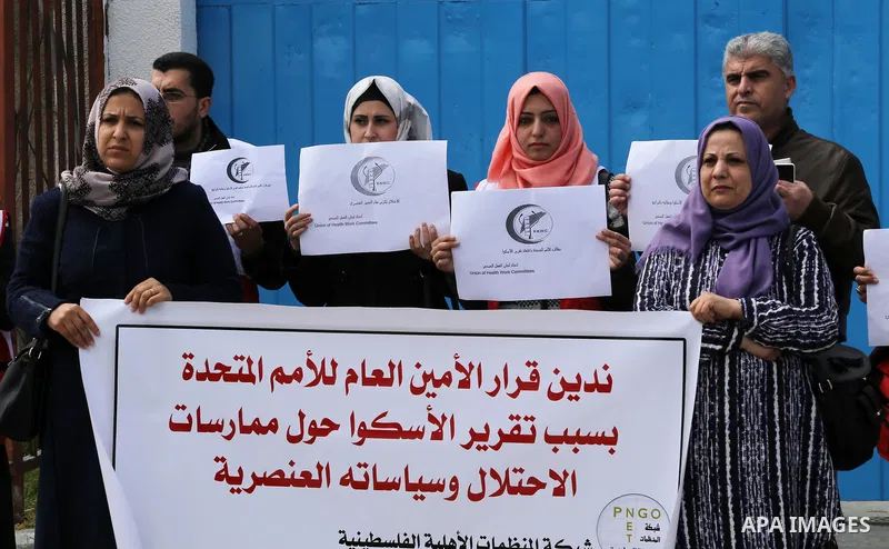Palestinians hold banners during a protest against the U.N. Secretary-General Antonio Guterres decision to remove Israeli 'apartheid' report from Economic and Social Commission for Western Asia (ESCWA) website, in front...