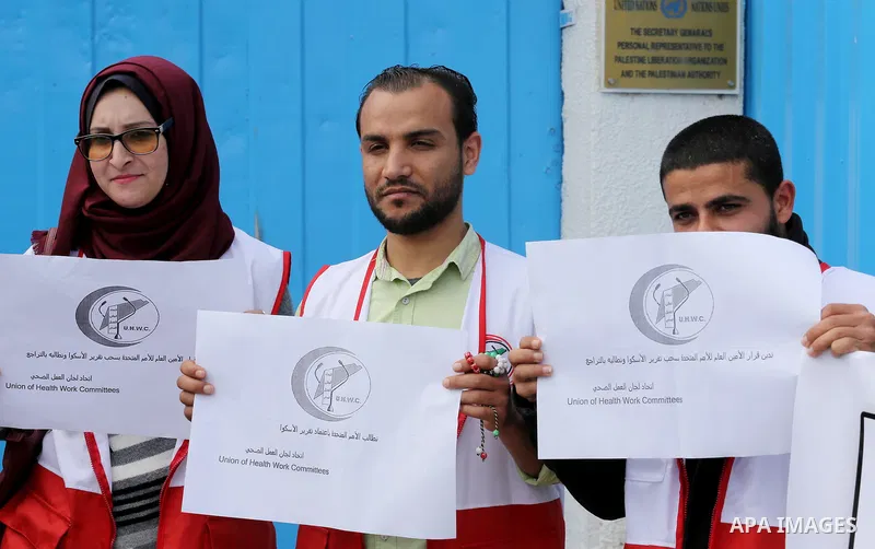 Palestinians hold banners during a protest against the U.N. Secretary-General Antonio Guterres decision to remove Israeli 'apartheid' report from Economic and Social Commission for Western Asia (ESCWA) website, in front...