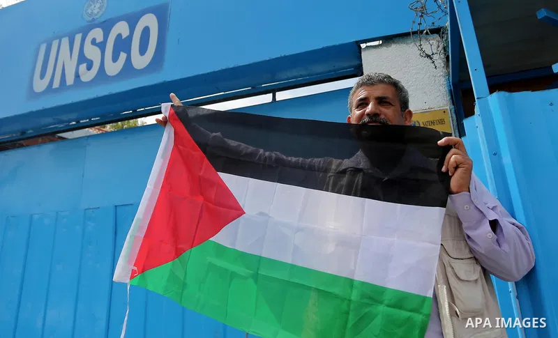 Palestinians hold banners during a protest against the U.N. Secretary-General Antonio Guterres decision to remove Israeli 'apartheid' report from Economic and Social Commission for Western Asia (ESCWA) website, in front...