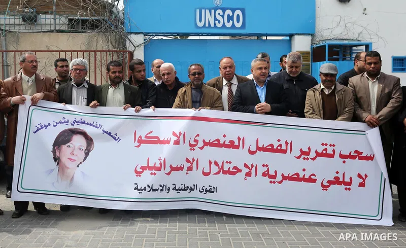 Palestinians hold banners during a protest against the U.N. Secretary-General Antonio Guterres decision to remove Israeli 'apartheid' report from Economic and Social Commission for Western Asia (ESCWA) website, in front...