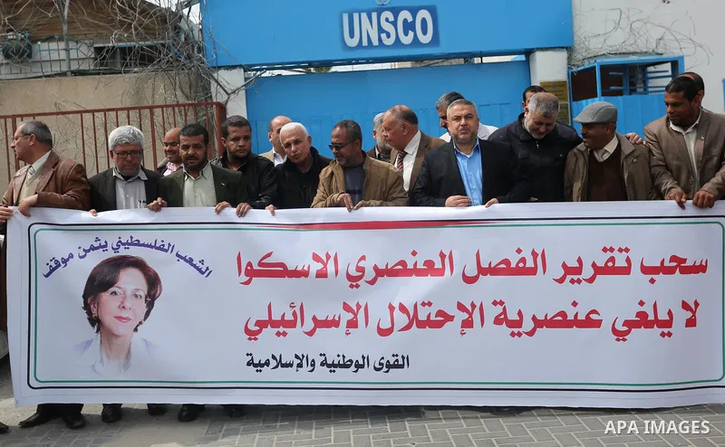 Palestinians hold banners during a protest against the U.N. Secretary-General Antonio Guterres decision to remove Israeli 'apartheid' report from Economic and Social Commission for Western Asia (ESCWA) website, in front...