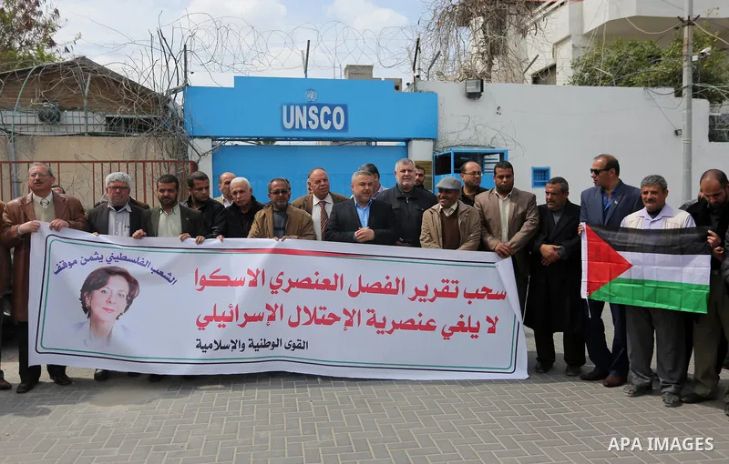 Palestinians hold banners during a protest against the U.N. Secretary-General Antonio Guterres decision to remove Israeli 'apartheid' report from Economic and Social Commission for Western Asia (ESCWA) website, in front...