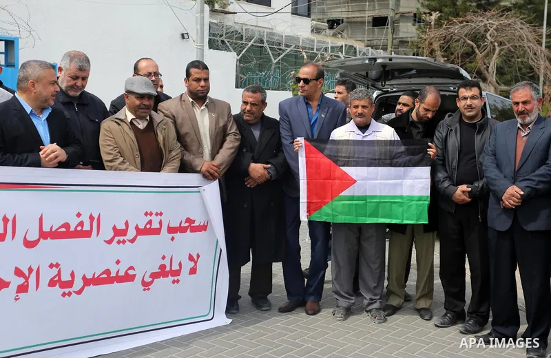 Palestinians hold banners during a protest against the U.N. Secretary-General Antonio Guterres decision to remove Israeli 'apartheid' report from Economic and Social Commission for Western Asia (ESCWA) website, in front...