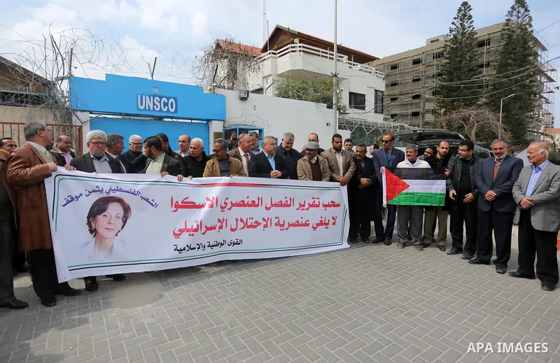 Palestinians hold banners during a protest against the U.N. Secretary-General Antonio Guterres decision to remove Israeli 'apartheid' report from Economic and Social Commission for Western Asia (ESCWA) website, in front...