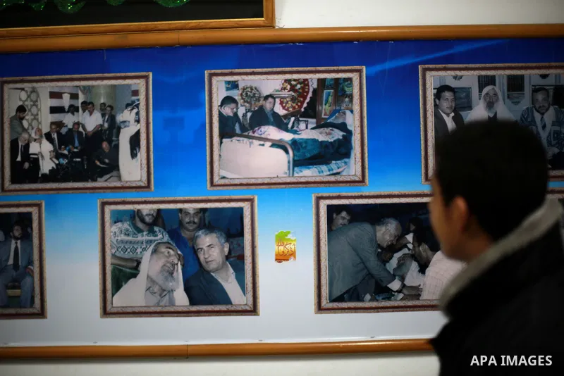 A Palestinian youth walks past pictures for late Hamas leader Sheikh Ahmed Yassin who was killed in an Israeli attack, in his house marking the thirteenth anniversary of his death, in Gaza City, March 21, 2017. Photo by...