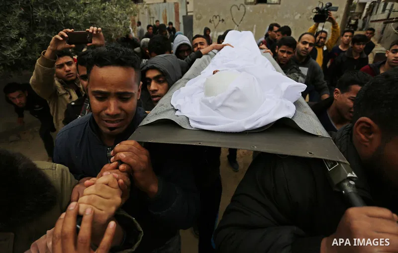 Mourners carry the body of Palestinian Youssef Abu Azra, who according to hospital officials was killed by Israeli fire and whom the Israeli forces said was detected with other suspects near the security fence, during hi...