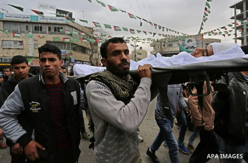 Mourners carry the body of Palestinian Youssef Abu Azra, who according to hospital officials was killed by Israeli fire and whom the Israeli forces said was detected with other suspects near the security fence, during hi...