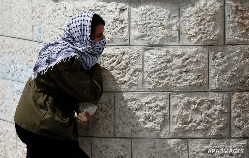 A female Palestinian protesters carries stones during clashes with Israeli border policemen following a protest to demand the return of bodies of Palestinians who were allegedly involved in attacks and consequently kille...