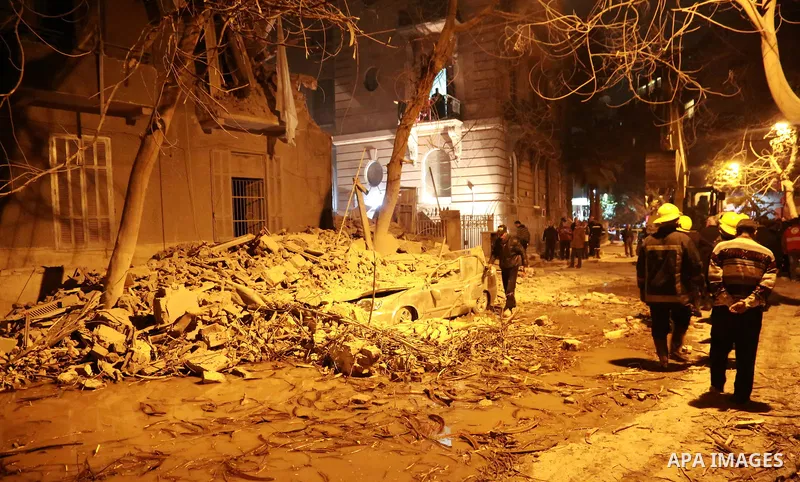 Egyptian civil defense members inspect the damage in front of the collapsed building in Garden City area in downtown Cairo on March 25, 2017. Photo by Amr Sayed