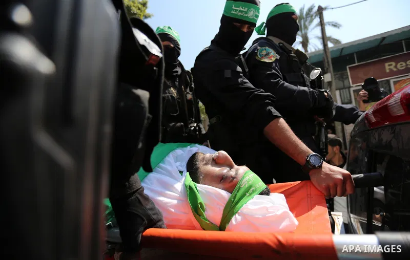 Members of the Ezzedine al-Qassam Brigades, the military wing of the Palestinian Islamist movement Hamas carry the body of Hamas official, Mazen Faqha who was freed by Israel in a 2011 prisoner swap during his funeral in...
