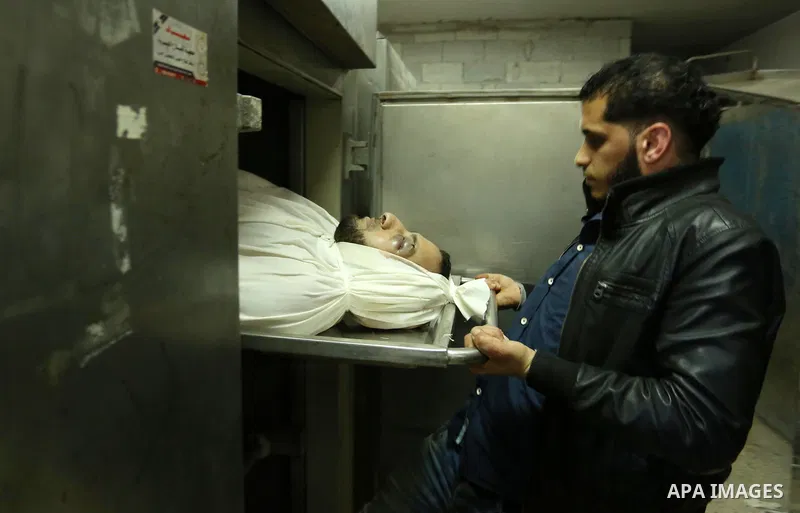 A Palestinian man looks at the body of of Hamas official, Mazen Faqha who was freed by Israel in a 2011 prisoner swap at a hospital morgue in Gaza City March 25, 2017. Faqha was released along with more than 1,000 other...