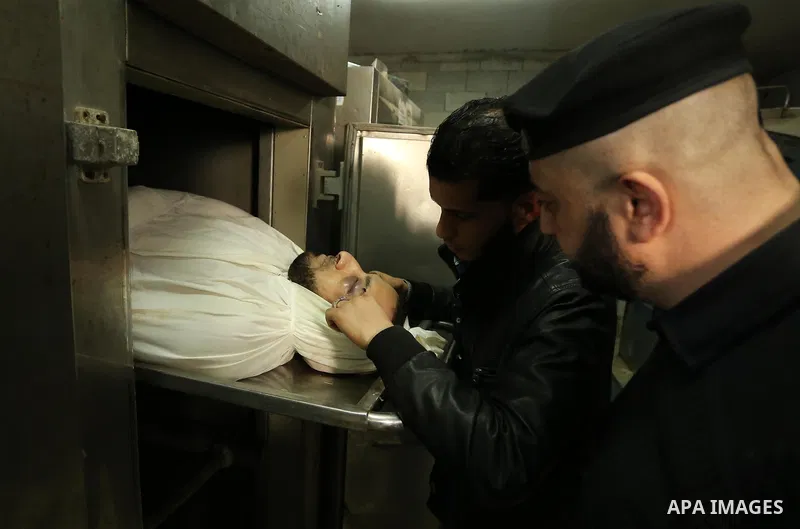 A Palestinian man looks at the body of of Hamas official, Mazen Faqha who was freed by Israel in a 2011 prisoner swap at a hospital morgue in Gaza City March 25, 2017. Faqha was released along with more than 1,000 other...
