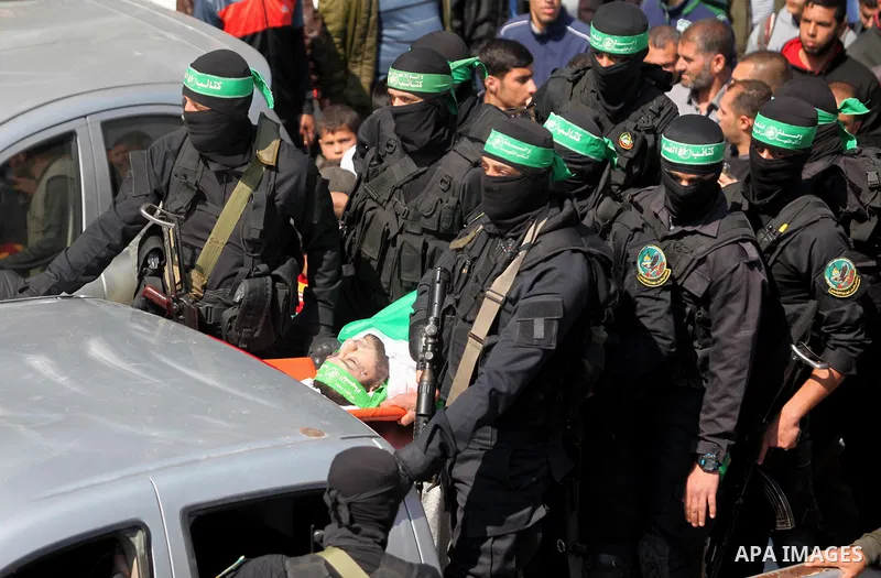 Members of the Ezzedine al-Qassam Brigades, the military wing of the Palestinian Islamist movement Hamas carry the body of Hamas official, Mazen Faqha who was freed by Israel in a 2011 prisoner swap during his funeral in...