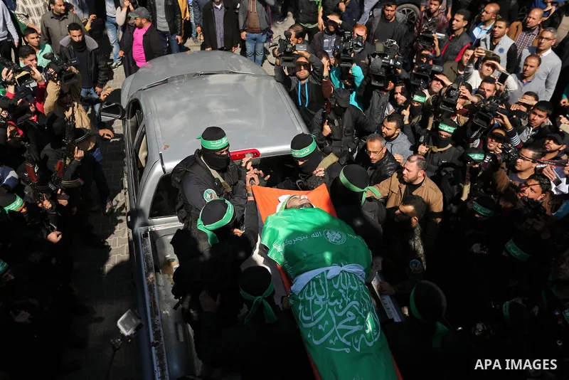 Members of the Ezzedine al-Qassam Brigades, the military wing of the Palestinian Islamist movement Hamas carry the body of Hamas official, Mazen Faqha who was freed by Israel in a 2011 prisoner swap during his funeral in...