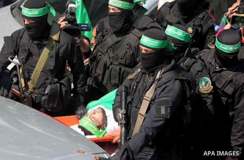 Members of the Ezzedine al-Qassam Brigades, the military wing of the Palestinian Islamist movement Hamas carry the body of Hamas official, Mazen Faqha who was freed by Israel in a 2011 prisoner swap during his funeral in...
