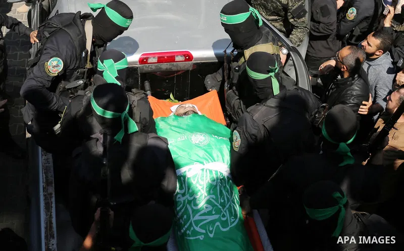 Members of the Ezzedine al-Qassam Brigades, the military wing of the Palestinian Islamist movement Hamas carry the body of Hamas official, Mazen Faqha who was freed by Israel in a 2011 prisoner swap during his funeral in...