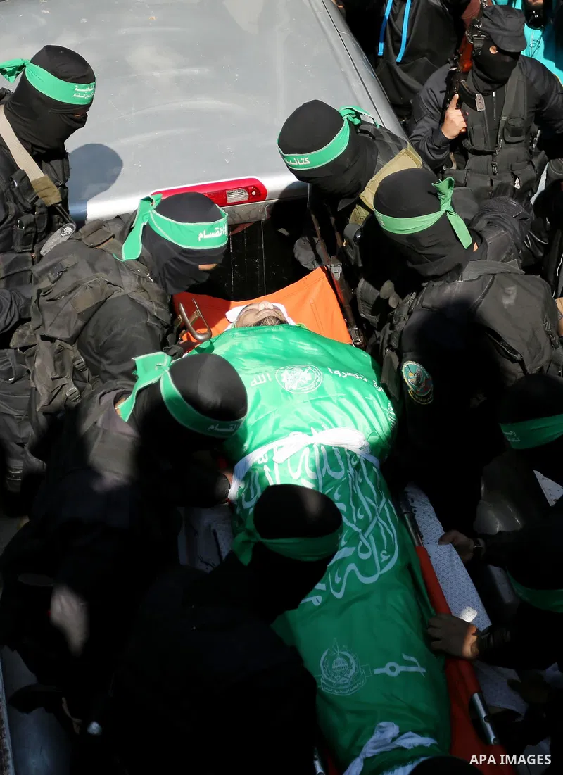 Members of the Ezzedine al-Qassam Brigades, the military wing of the Palestinian Islamist movement Hamas carry the body of Hamas official, Mazen Faqha who was freed by Israel in a 2011 prisoner swap during his funeral in...