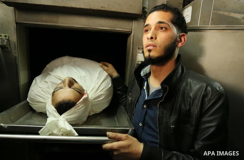 A Palestinian man looks at the body of of Hamas official, Mazen Faqha who was freed by Israel in a 2011 prisoner swap at a hospital morgue in Gaza City March 25, 2017. Faqha was released along with more than 1,000 other...