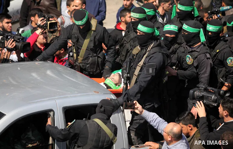 Members of the Ezzedine al-Qassam Brigades, the military wing of the Palestinian Islamist movement Hamas carry the body of Hamas official, Mazen Faqha who was freed by Israel in a 2011 prisoner swap during his funeral in...