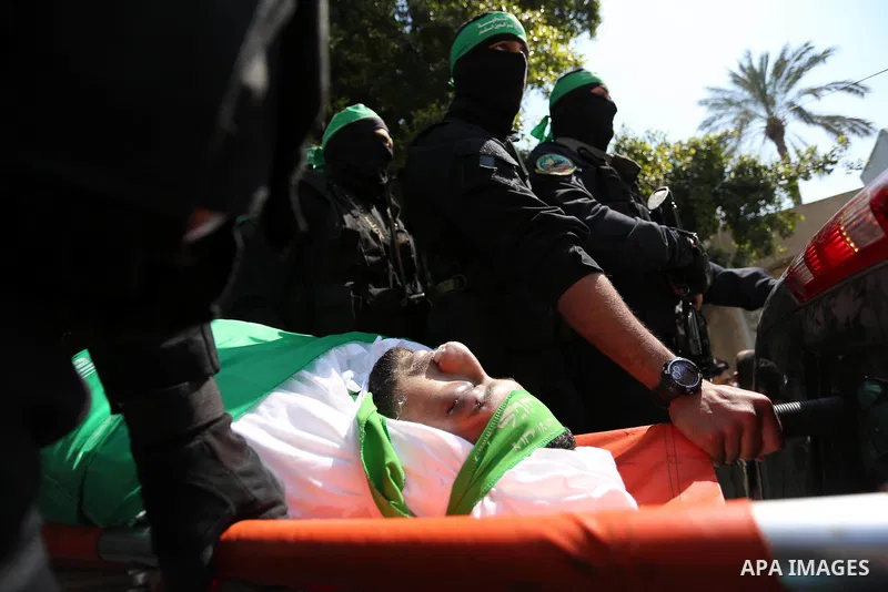 Members of the Ezzedine al-Qassam Brigades, the military wing of the Palestinian Islamist movement Hamas carry the body of Hamas official, Mazen Faqha who was freed by Israel in a 2011 prisoner swap during his funeral in...