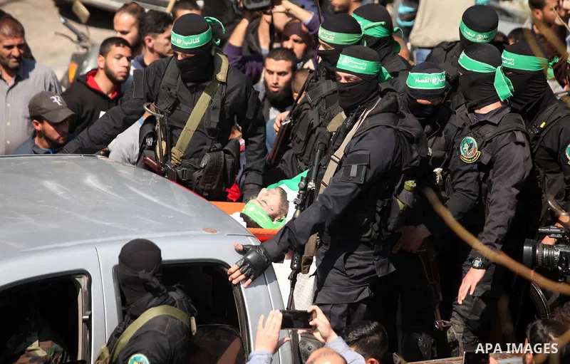 Members of the Ezzedine al-Qassam Brigades, the military wing of the Palestinian Islamist movement Hamas carry the body of Hamas official, Mazen Faqha who was freed by Israel in a 2011 prisoner swap during his funeral in...