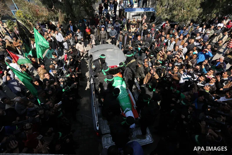 Members of the Ezzedine al-Qassam Brigades, the military wing of the Palestinian Islamist movement Hamas carry the body of Hamas official, Mazen Faqha who was freed by Israel in a 2011 prisoner swap during his funeral in...
