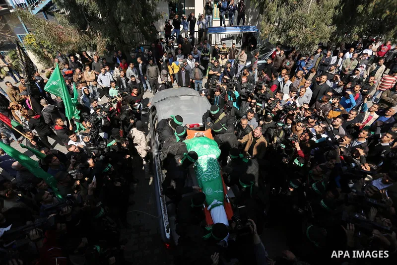 Members of the Ezzedine al-Qassam Brigades, the military wing of the Palestinian Islamist movement Hamas carry the body of Hamas official, Mazen Faqha who was freed by Israel in a 2011 prisoner swap during his funeral in...