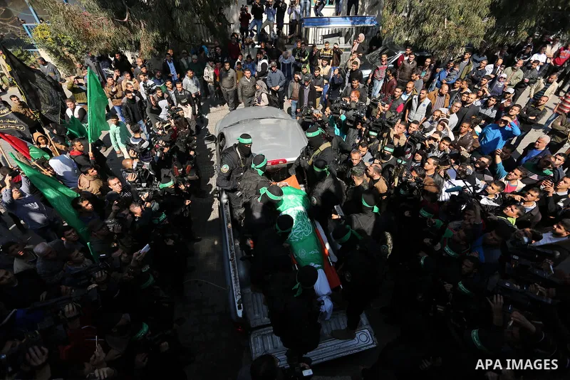 Members of the Ezzedine al-Qassam Brigades, the military wing of the Palestinian Islamist movement Hamas carry the body of Hamas official, Mazen Faqha who was freed by Israel in a 2011 prisoner swap during his funeral in...