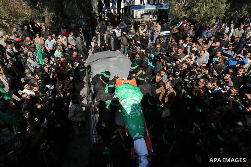 Members of the Ezzedine al-Qassam Brigades, the military wing of the Palestinian Islamist movement Hamas carry the body of Hamas official, Mazen Faqha who was freed by Israel in a 2011 prisoner swap during his funeral in...