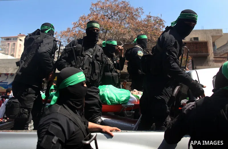 Members of the Ezzedine al-Qassam Brigades, the military wing of the Palestinian Islamist movement Hamas carry the body of Hamas official, Mazen Faqha who was freed by Israel in a 2011 prisoner swap during his funeral in...