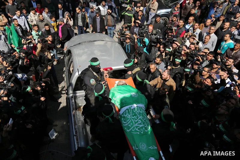 Members of the Ezzedine al-Qassam Brigades, the military wing of the Palestinian Islamist movement Hamas carry the body of Hamas official, Mazen Faqha who was freed by Israel in a 2011 prisoner swap during his funeral in...